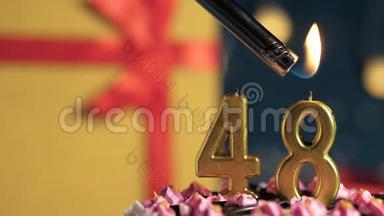 生日蛋糕编号48金色蜡烛用打火机点燃，蓝色背景礼品黄色盒子用红丝带系好